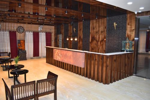 a bar in a room with benches and tables at Hotel La Vista Inn in Tinsukia