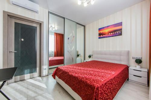 a bedroom with a bed with a red bedspread at Стильна квартира в сучасному комплексі метро Нивки in Kyiv