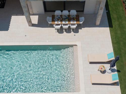 an overhead view of a swimming pool with a table and chairs at Ionian Trilogy Luxury Villas in Sami