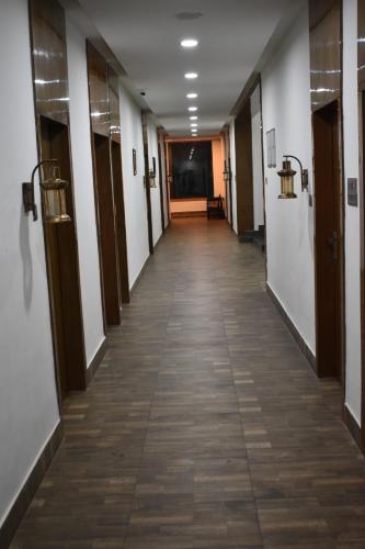 an empty hallway of a building with doors and tiles at Hotel La Vista Inn in Tinsukia