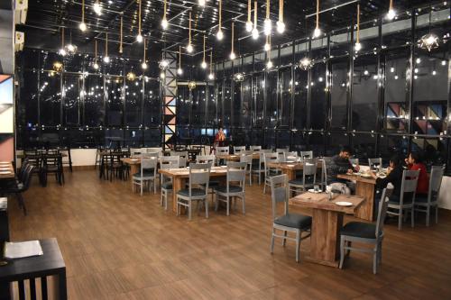 a dining room with tables and chairs and lights at Hotel La Vista Inn in Tinsukia