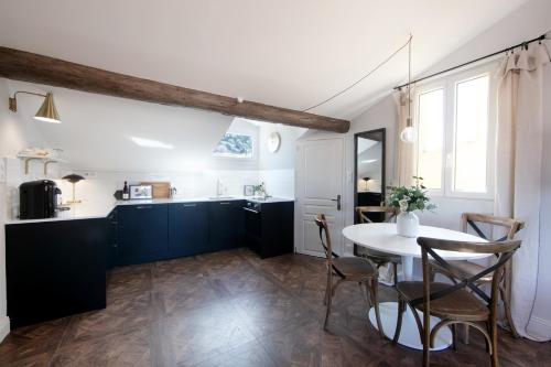 une cuisine et une salle à manger avec une table et des chaises dans l'établissement COCOON LOFT - MAGNIFIQUE LOFT SOUS TOIT, REFAIT A NEUF, VUES SPLENDIDES, CLIM, WIFi, à Nice