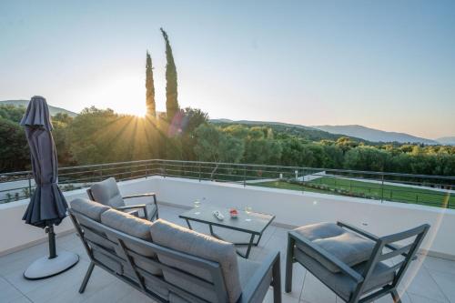 a patio with chairs and a table on a balcony at Ionian Trilogy Luxury Villas in Sami