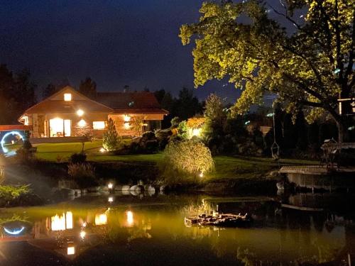 a house with lights on a lake at night at Residence R&R in Karvys