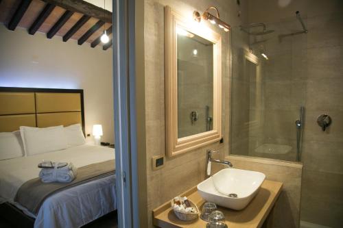 a bathroom with a bed and a sink and a shower at Cortona Resort & Spa - Villa Aurea in Cortona