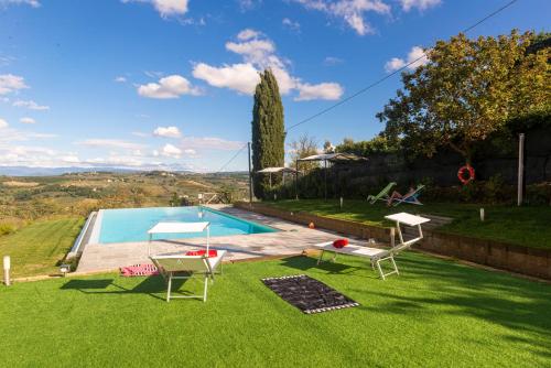 une arrière-cour avec une piscine et deux chaises longues dans l'établissement Villa la torre, à Montespertoli