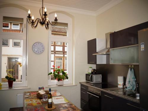 a kitchen with a table and a clock on the wall at EXKLUSIVES 4* Appartement im Herzen von Einbeck! 3 Schlafzimmer, Garten! in Einbeck