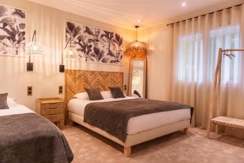 1 dormitorio con 2 camas y espejo en The Originals Boutique, Parc Hôtel, Orléans Sud, en La Chapelle-Saint-Mesmin