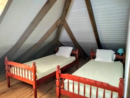Appart'hotel La croisière في Gourbeyre: سريرين في غرفة مع سقف