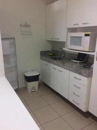 熱河市的住宿－Águas da Serra Apart Service 728A，厨房配有水槽和微波炉