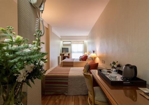 a hotel room with two beds and a desk at Hotel Solans Riviera in Rosario
