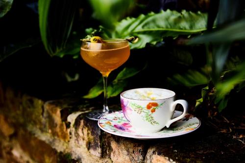 a drink and a cup of coffee on a stone wall at Kimpton Hotel Fontenot by IHG in New Orleans