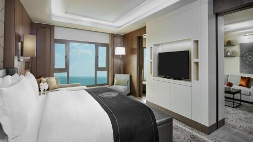 een slaapkamer met een groot bed en een televisie bij InterContinental Doha Beach & Spa by IHG in Doha