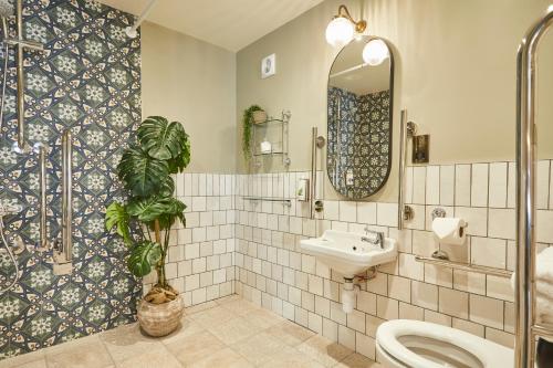 a bathroom with a toilet and a sink and a mirror at The Swan Inn in Winscombe