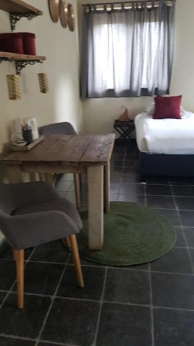 a living room with a wooden table and a couch at B&B de Remketting in Slijk-Ewijk