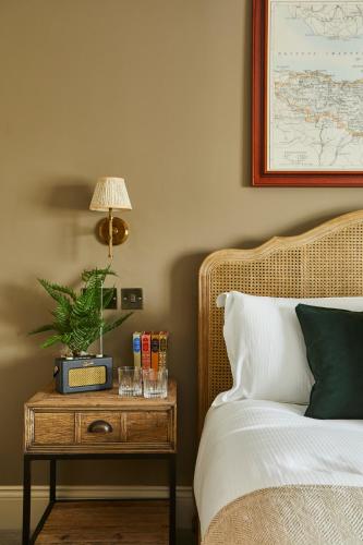 a bedroom with a bed and a table with a lamp at The Swan Inn in Winscombe