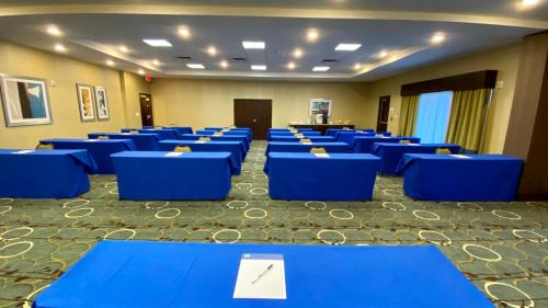 a room filled with blue tables and chairs at Holiday Inn Express Hotel & Suites Orlando East-UCF Area by IHG in Orlando