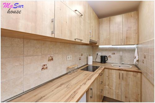 a kitchen with wooden cabinets and a sink at Masur House and Tours in Yerevan