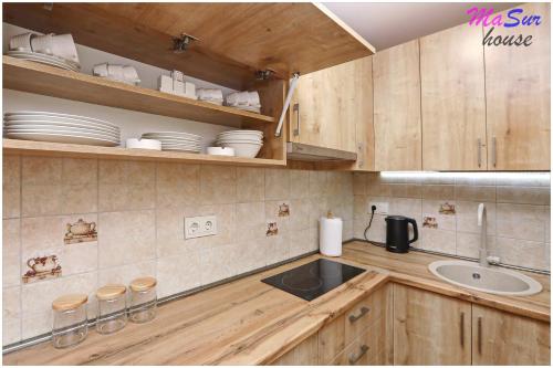 a kitchen with wooden cabinets and a sink and plates at Masur House and Tours in Yerevan
