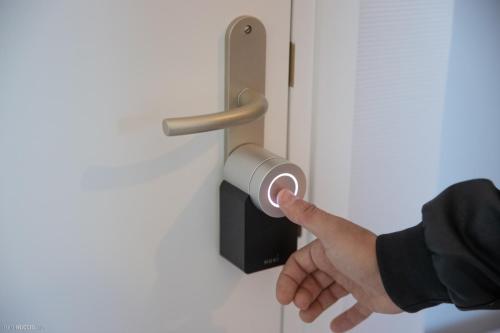 a hand holding a roll of toilet paper on a door at Modern Living in Huningue
