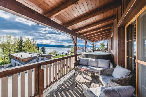 a balcony with a couch and a table and chairs at Hotel Resort Relax in Dolní Vltavice