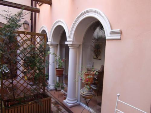 an entry to a building with arches and potted plants at Mondo Antico B&B in Cesena