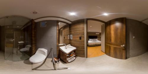 a bathroom with a sink and a bathroom with a bed at Albura Hotel in Pereira