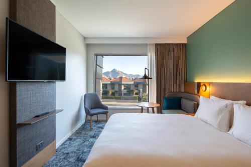 a hotel room with two beds and a television at Holiday Inn Express & Suites Queenstown, an IHG Hotel in Queenstown