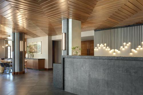 a lobby with a reception desk and wooden ceiling at Kimpton - Armory Hotel Bozeman, an IHG Hotel in Bozeman