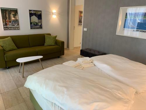 a hotel room with a bed and a couch at Park-Lodge Am Rohrbusch in Münster