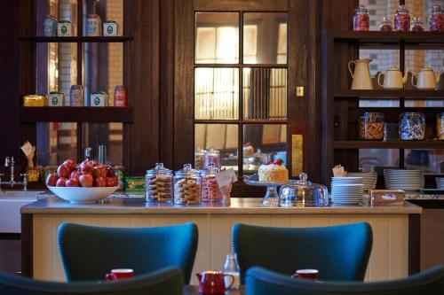 a restaurant with a table with a bowl of fruit on it at Kimpton Clocktower by IHG in Manchester