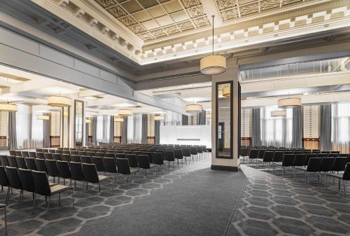 an empty room with chairs and tables and ceilings at Kimpton Clocktower by IHG in Manchester