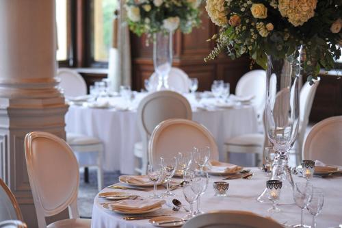 a dining room with white tables and chairs with wine glasses at The Milner York in York