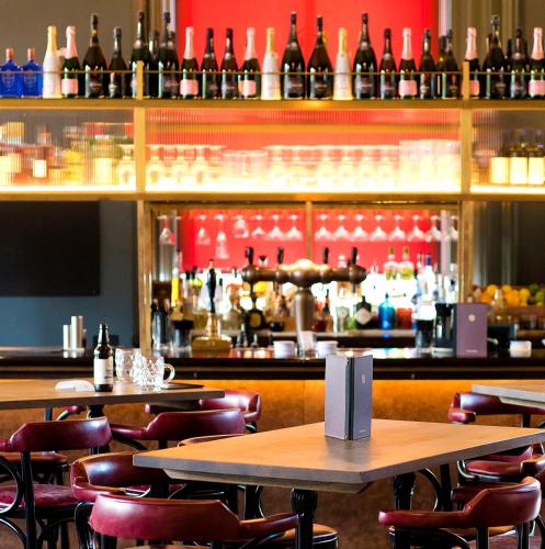 a bar with tables and chairs and wine bottles at The Milner York in York
