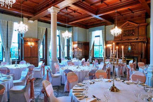 a banquet hall with white tables and chairs and chandeliers at The Milner York in York