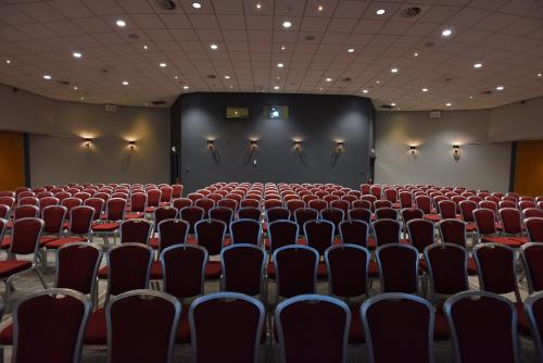 an auditorium with red chairs and a large screen at The Milner York in York