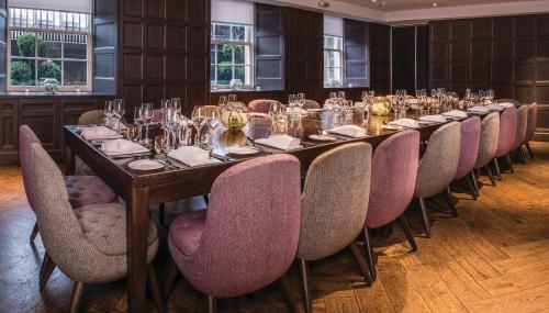 a long table in a room with chairs and wine glasses at Kimpton Blythswood Square Hotel & Spa by IHG in Glasgow
