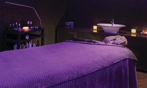 a bathroom with a purple bed and a sink at Kimpton Blythswood Square Hotel & Spa by IHG in Glasgow
