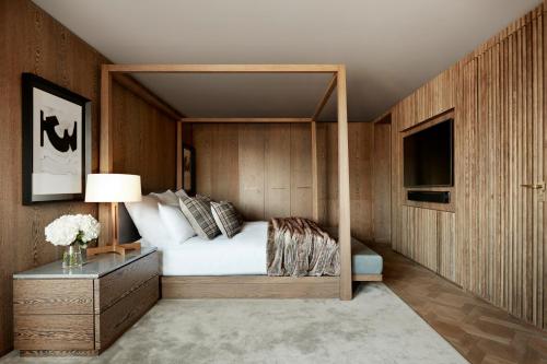 a bedroom with a canopy bed and a television at Kimpton Blythswood Square Hotel & Spa by IHG in Glasgow
