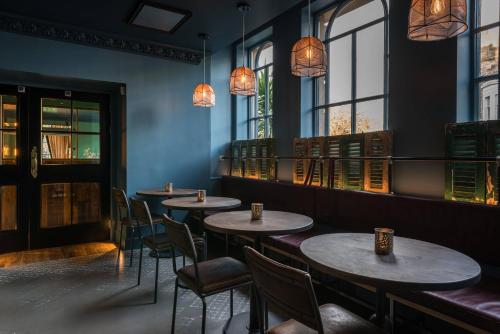 a row of tables in a restaurant with windows at Kimpton Charlotte Square by IHG in Edinburgh