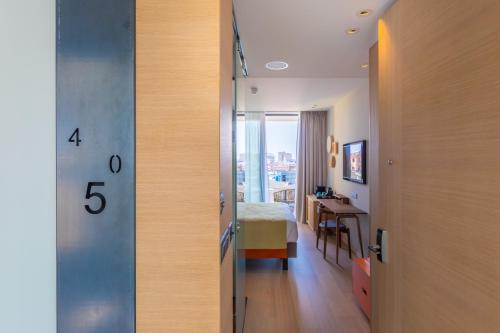 a room with a bed and a clock on the door at Hotel Indigo Larnaca by IHG-ADULTS ONLY in Larnaka