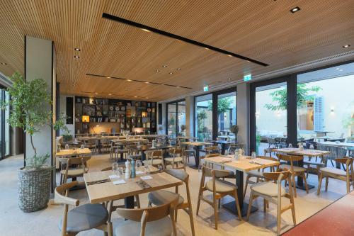 a restaurant with tables and chairs and windows at Hotel Indigo Larnaca by IHG-ADULTS ONLY in Larnaka