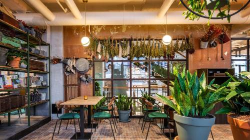 a restaurant with plants and a table and chairs at Hotel Indigo Brussels - City by IHG in Brussels