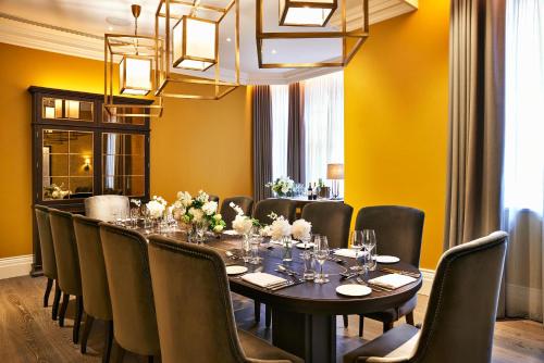a dining room with a long table and chairs at Kimpton Fitzroy London by IHG in London