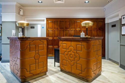 a kitchen with wooden cabinets and a wooden table at Hotel Indigo - Chester, an IHG Hotel in Chester