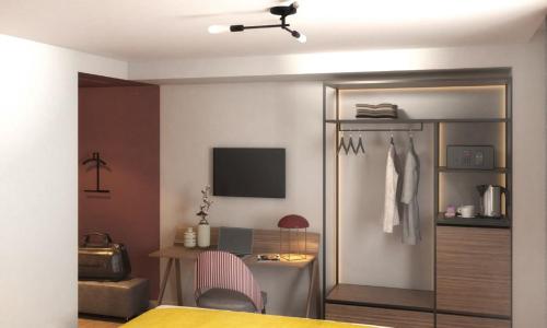 a room with a bedroom with a desk and a television at Hotel Indigo Madrid - Princesa by IHG in Madrid