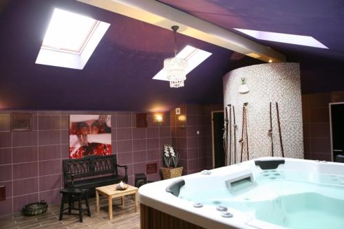 a bathroom with a large tub and a mirror at Hotel Złoty Młyn Majków in Piotrków Trybunalski