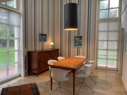 a dining room with a wooden table and white chairs at Park-Lodge Am Rohrbusch in Münster