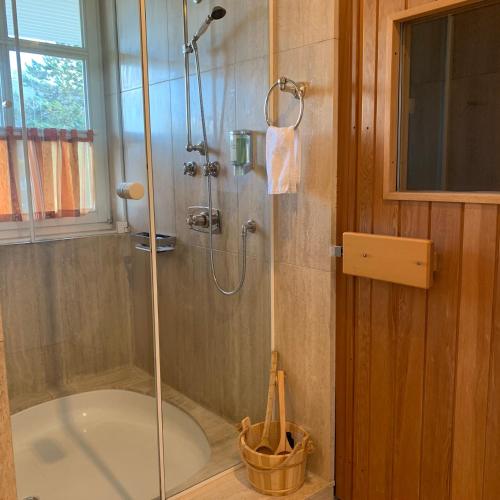 a bathroom with a shower and a bath tub at Park-Lodge Am Rohrbusch in Münster