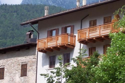 a building with wooden balconies on the side of it at Casa Rondine in Molveno